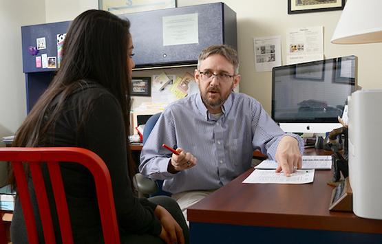 A professor meets with a student in his office