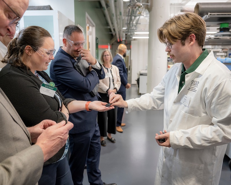 An OHIO researcher hands out items that were created in a 3D printer to guests at the Grand Opening Ceremony