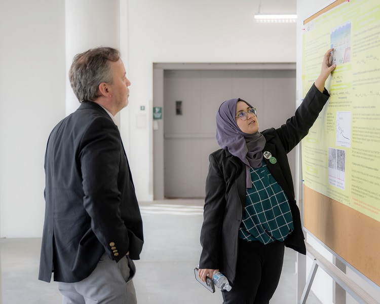 An OHIO students discusses her research presentation with a guest at the grand opening event