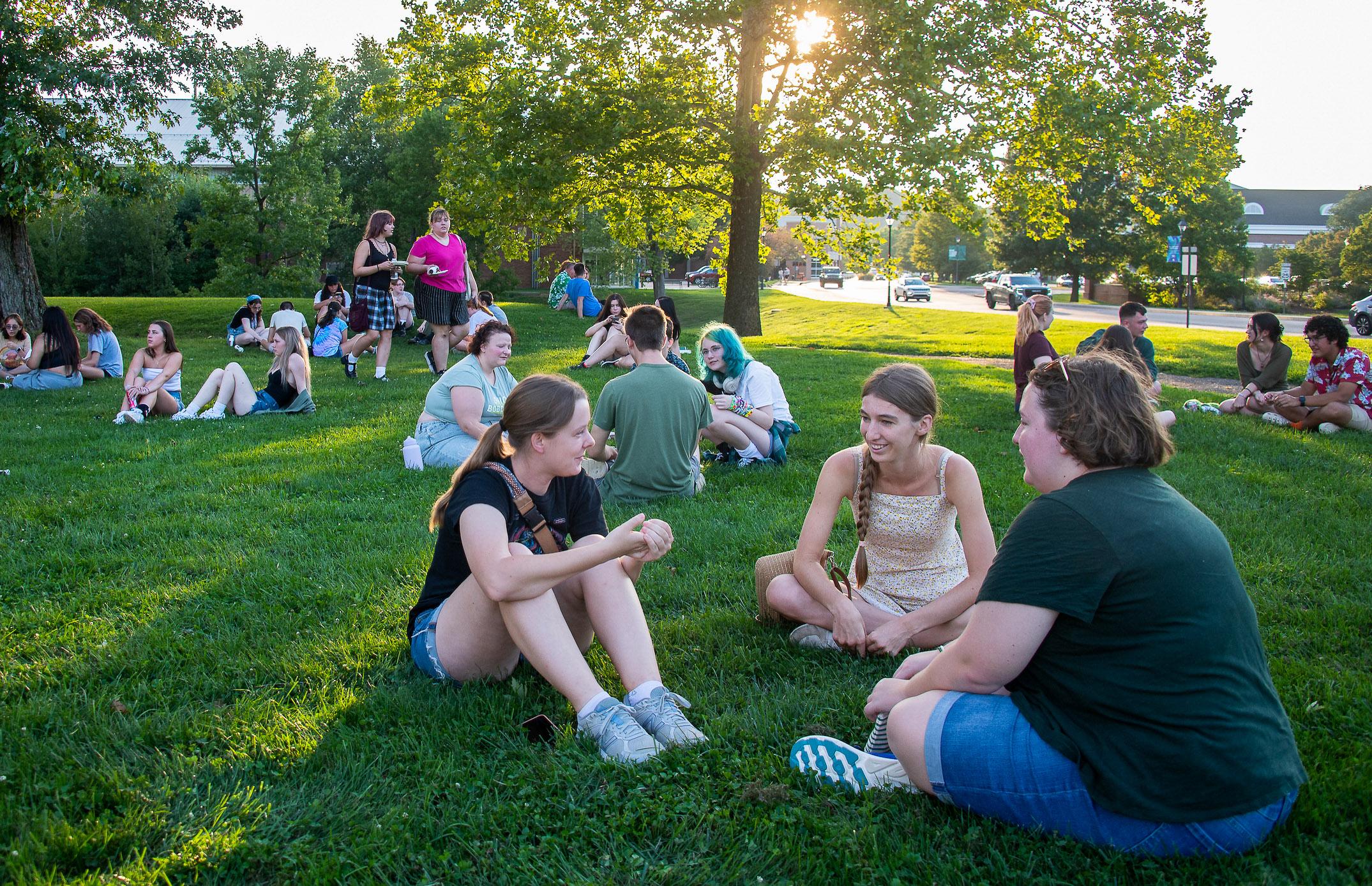 group of students sitting together on the grass